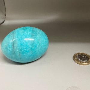 Może przedstawiać: Gładkie, jasnoniebieskie, owalne jajko marmurowe z białymi smugami.