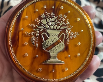 Vintage Lucite Puderdose aus Bernstein von Elizabeth Arden mit einem goldenen Urnenmotiv. Gespiegelt, puder, keine Pusteblume,
