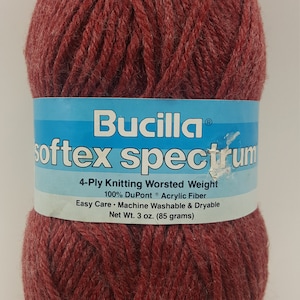 May include: A ball of Bucilla Softex Spectrum 4-Ply Knitting Worsted Weight yarn in a deep red color. The label reads "Bucilla® softex spectrum 4-Ply Knitting Worsted Weight 100% DuPont® Acrylic Fiber Easy Care Machine Washable & Dryable Net Wt. 3 oz. (85 grams)"