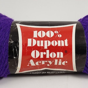 Może przedstawiać: Motka fioletowej przędzy z etykietą "100% Dupont Orlon Akryl".