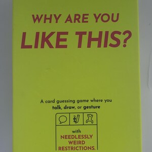 May include: A bright yellow card game box with the text "WHY ARE YOU LIKE THIS?" in red. The box says it's a card guessing game where you talk, draw, or gesture. It's made by Exploding Kittens and includes "NEEDLESSLY WEIRD RESTRICTIONS."