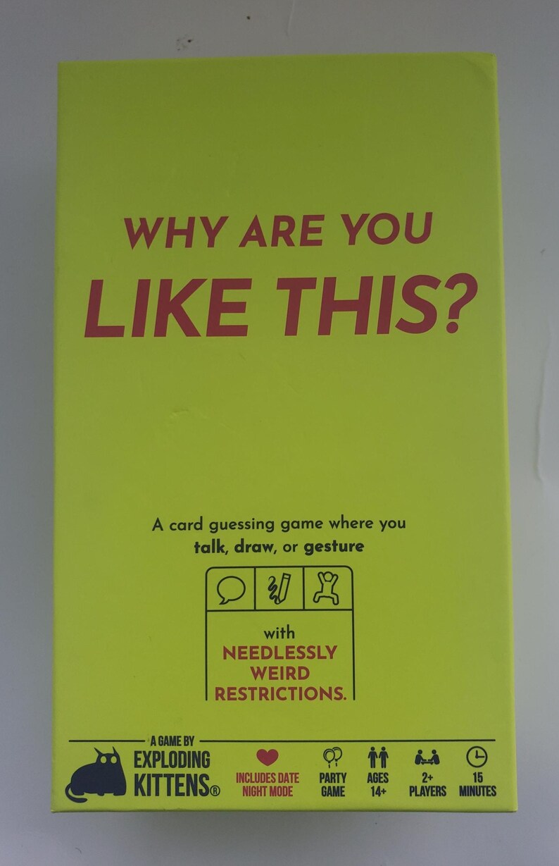 May include: A bright yellow card game box with the text "WHY ARE YOU LIKE THIS?" in large red letters. The box also includes the text "A card guessing game" and icons indicating the game is for 2+ players, ages 14+, and takes 15 minutes to play.
