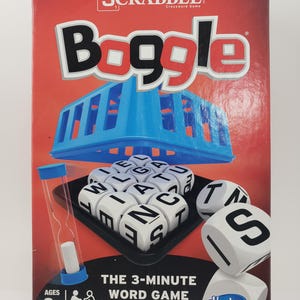 Könnte beinhalten: Eine rote Schachtel mit den Worten "From the makers of SCRABBLE Crossword Game" und "Boggle" in weißen Buchstaben. Die Schachtel zeigt einen blauen Plastikwürfel mit weißen Buchstaben und ein schwarzes Tablett mit weißen Buchstabenwürfeln. Die Schachtel zeigt auch eine Sanduhr und einen weißen Kreidestift. Die Schachtel sagt "The 3-Minute Word Game" und "Ages 8+ 1+ Players". Die Schachtel hat auch das Hasbro Gaming Logo.