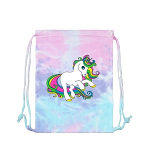 May include: A tie-dye drawstring bag with a white unicorn graphic. The unicorn has a colorful mane and tail with yellow hooves. The bag's background is a blend of pink, blue, and purple hues, and it has white drawstrings.