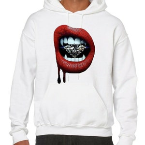 May include: White hooded sweatshirt featuring a graphic print of a red mouth with fangs biting a large diamond.