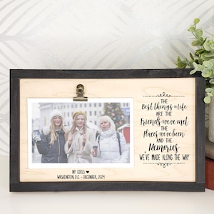 May include: Horizontal photo frame with a black border and a natural wood interior. The frame holds a photo of three people and includes the text "The Best things in life are the friends we've met, the places we've been, and the memories we've made along the way."