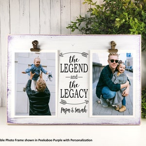 May include: A white wooden photo frame with two openings for pictures. The frame has a purple painted edge and a black inscription that reads "the LEGEND -and- the LEGACY Papa & Sarah".