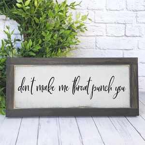 May include: A framed wooden sign with white background and black text that reads "don't make me throat punch you". The sign is 3x8 inches and is shown in a foggy night setting.