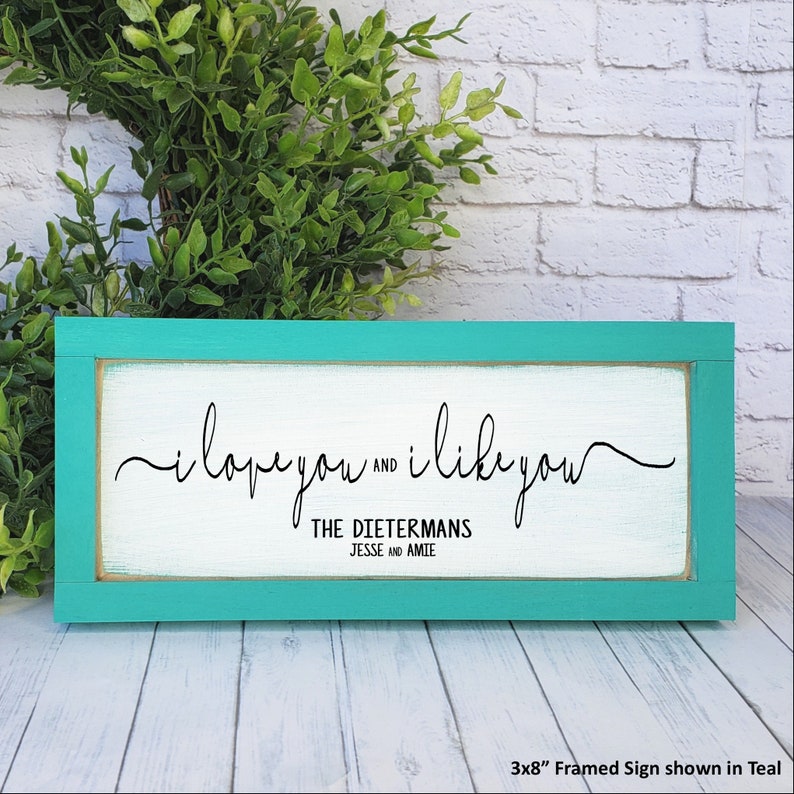 May include: Teal framed wooden sign with the text "i love you and i like you" and "THE DIETERMANS JESSE and AMIE". The sign is 3x8 inches.