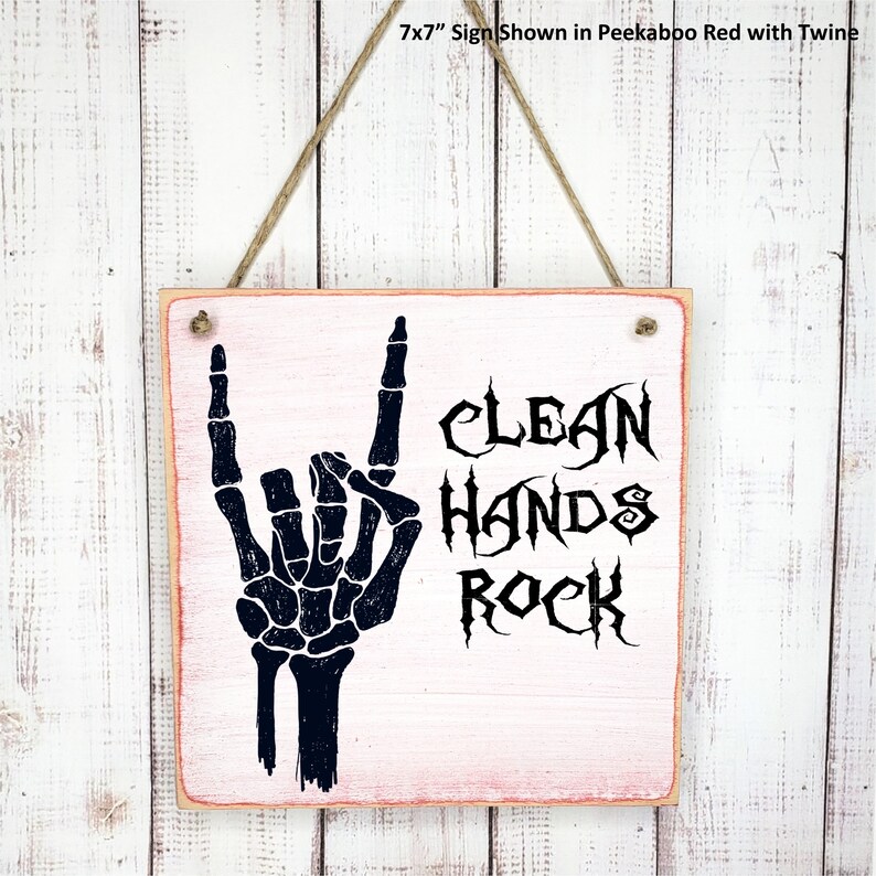 Puede incluir: Un letrero de madera de 17,8 x 17,8 cm con fondo rosa y texto negro que dice "Clean Hands Rock". Se muestra una mano de esqueleto negra haciendo el gesto de rock and roll.