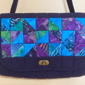bolsa de hombro. Solapa de patchwork acolchada sobre azul marino con tira ajustable