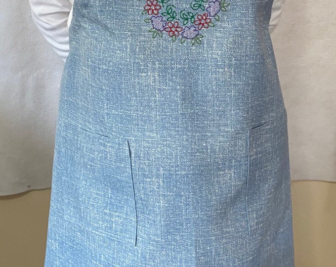 A beautiful and durable apron with decorative appliqué on the bib.