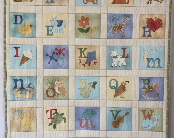 Baby quilt, wall hanging, or play blanket. Alphabet design measures 36” by 42” Machine quilted, hand stitched binding