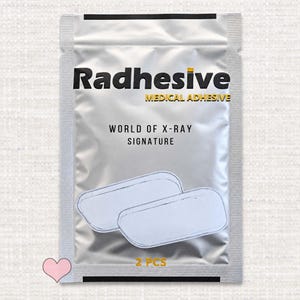 May include: A silver rectangular medical adhesive packet labeled Radhesive Medical Adhesive World of X-Ray Signature. The front of the package displays two white rectangular adhesive patches and the text 2 PCS in yellow.