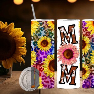May include: Three stainless steel tumblers with a sunflower and cowhide pattern. The middle tumbler has the letters "MOM" in brown with a cowhide pattern.