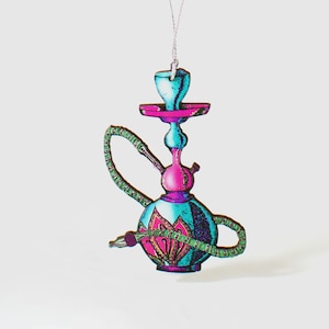 May include: A turquoise and pink glass hookah with a green and gold patterned design. The hookah is hanging from a string and has a long, thin hose.