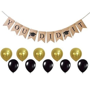 May include: A graduation party banner with the text "YOU DID IT" in black letters on a burlap background. The banner is decorated with black graduation caps. The banner is hanging from a string. There are also 10 balloons, 5 gold and 5 black.