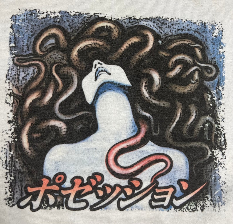 Puede incluir: Una ilustraci&oacute;n en blanco y negro de una mujer con serpientes como cabello. La boca de la mujer est&aacute; abierta y ella est&aacute; mirando hacia arriba. El texto "オセッショ" est&aacute; impreso debajo de la imagen.