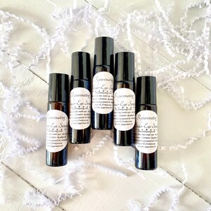 Puede incluir: Cinco peque&ntilde;os frascos de vidrio marr&oacute;n oscuro con bolas rodantes. Cada frasco tiene una etiqueta blanca con el texto "Rejuvenating Under-Eye Serum" y una lista de ingredientes. Los frascos est&aacute;n dispuestos en c&iacute;rculo sobre una superficie blanca.