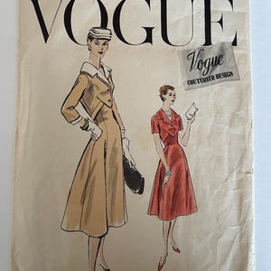 Op de afbeelding: Vintage Vogue Couturier Design naaipatroon met twee jurken voor dames. De jurk links is een beige manteljurk met een witte kraag. De jurk rechts is een rode jurk met een witte kraag. Het patroon is gedrukt en geperforeerd.