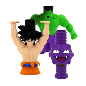 May include: Three figurines, a green Hulk, a purple Gengar, and a yellow and orange Goku, all with a cartoon style.