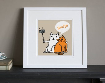 Könnte beinhalten: Ein gerahmtes Kreuzstich-Design mit zwei Katzen, eine weiße und eine orange. Die weiße Katze hält einen Selfie-Stick mit einer Kamera. Die orange Katze sitzt neben der weißen Katze. Eine Sprechblase über der weißen Katze sagt "Lächeln".