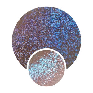 May include: Close-up of iridescent blue and purple glitter, showing the sparkle and texture of the glitter.