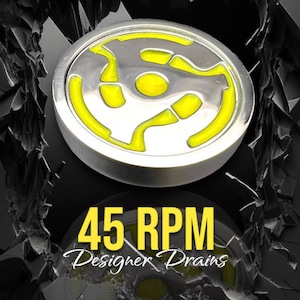 May include: A silver-colored metal disc with a yellow 45 RPM record label design. The text "45 RPM Designer Drains" is below the disc.