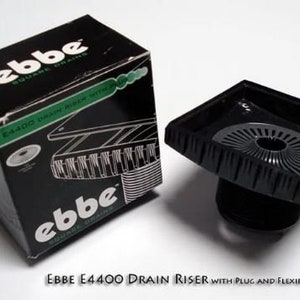 May include: Black square drain riser with a black plug and a gray hair trap. The packaging says "Ebbe Square Drains E4400 Drain Riser with Plug and Flexible Hair Trap".