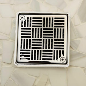 May include: A square, chrome-plated drain cover with a black, geometric pattern. The drain cover has two visible screws.