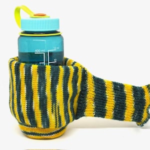 May include: A blue water bottle with a yellow and blue lid is nestled in a knitted cozy. The cozy has yellow and blue stripes. The bottle is marked with 14 oz and 400 ml measurements.