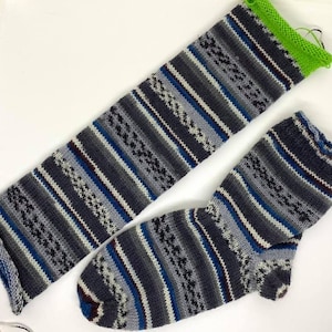 May include: A pair of grey, blue, and white striped knitted socks. One sock is folded and the other is laid flat.