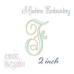 Op de afbeelding: Een geborduurde letter F in lichtblauw en goud, 5 cm groot. De letter is in een cursief lettertype met een decoratieve versiering. Machineborduurwerk.