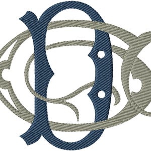 Peut inclure: Un monogramme brodé présentant une grande lettre D bleu foncé entrelacée avec une lettre C ornée gris clair. Le motif affiche une texture de point de satin visible sur les deux lettres, créant un aspect superposé et dimensionnel.
