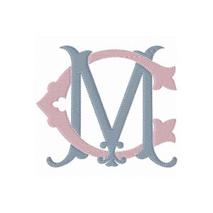 May include: An embroidered monogram featuring the letter M in a dusty blue thread intertwined with a decorative letter C in a soft pink thread. The design uses a satin stitch pattern to create a textured appearance for both letters.