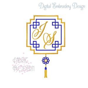 May include: Gold and blue monogram embroidery design with the letters "J" and "S" inside a square frame with a tassel hanging from the bottom. The design is perfect for adding a personalized touch to your projects.