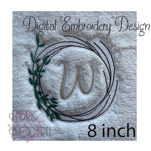 Puede incluir: Diseño de corona bordada con la letra W en el centro. La corona es marrón con hojas verdes y tiene un diámetro de 8 pulgadas.