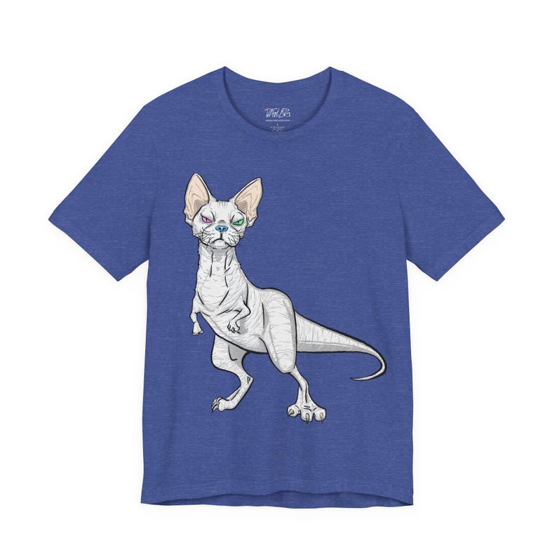 May include: A heather blue short-sleeve t-shirt featuring a graphic illustration of a hairless cat with a dinosaur-like body, a long tail, and heterochromia with one pink eye and one green eye. The shirt has a crew neckline and a brand logo inside.