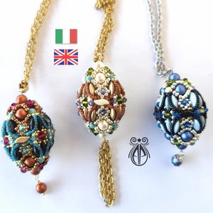 Può includere: Tre collane di perline con disegni intricati. Ogni collana presenta uno schema di colori diverso: una con perline di rame, turchese e nero, una con perline bianche, dorate e viola e una con perline blu, argentate e verdi.