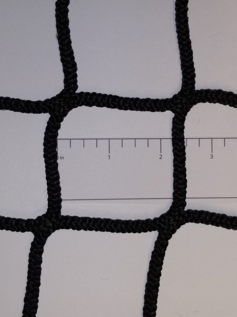 Pu&ograve; includere: Primo piano di una rete nera con un righello che mostra 7,6 cm. La rete &egrave; realizzata con una corda spessa e intrecciata.
