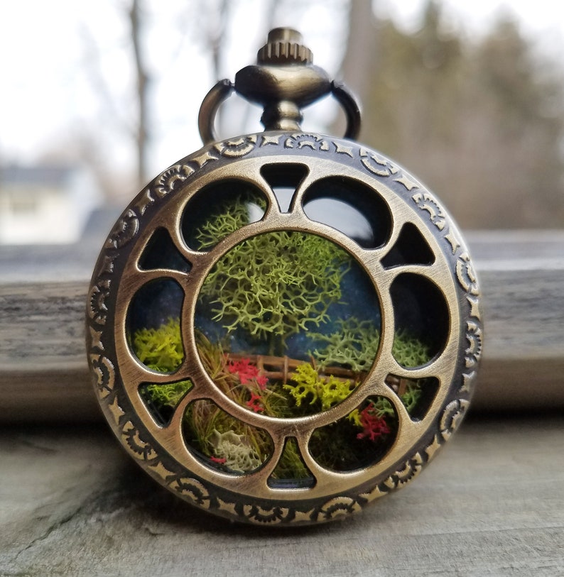 moss and twig landscape diorama in a pocketwatch.