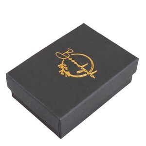 This photo shows that your jewelry will arrive in a custom black matte jewelry box with a gold foil-stamped Boomdyada logo centered on the outside of the lid. This elegant box is perfect for gift-giving! All orders ship the next business day.