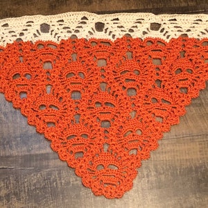 Peut inclure: Châle triangulaire au crochet, orange et crème. La partie orange présente un motif de crânes répétés, tandis que le bord supérieur est crème avec un motif festonné. Accessoire fait main pour Halloween ou les tenues gothiques.