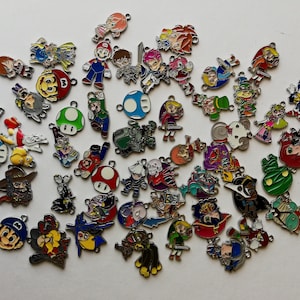 May include: A collection of colourful metal charms featuring various video game characters, including Mario, Link, Sonic the Hedgehog, and more. The charms are perfect for adding a touch of fun to jewellery, keyrings, or bags.