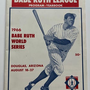 May include: A 1966 Official Babe Ruth League Program-Yearbook featuring a blue and white illustration of a baseball player swinging a bat. The cover includes red text reading 1966 Babe Ruth World Series, Douglas, Arizona, August 18-27, and 50 cents.