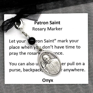 May include: A black onyx rosary marker with a silver charm featuring a picture of a saint. The charm is attached to a black beaded chain. The marker comes in a black organza bag. Let your "Patron Saint" mark your place when you don't have time to pray the rosary.