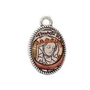 May include: An oval-shaped silver-toned pendant featuring a rope-style border. The center displays a printed illustration of a figure wearing a crown and head covering, with the text "a dudelle" visible above the head in a dark script font.