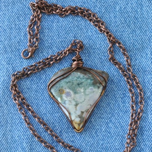 May include: A copper chain necklace with a pendant featuring a green, white and brown agate stone wrapped in copper wire.