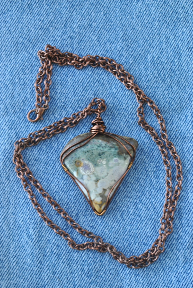 May include: A copper chain necklace with a pendant featuring a green, white and brown agate stone wrapped in copper wire.