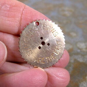 May include: A gold-colored metal saw blade with the text "Simonds Saws Are The Best" inscribed on the edge.